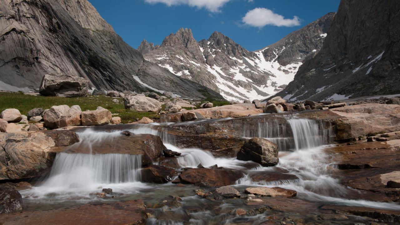 Image: a photograph of small, rushing falls of water over rocks at Titcomb Basin Cascade.