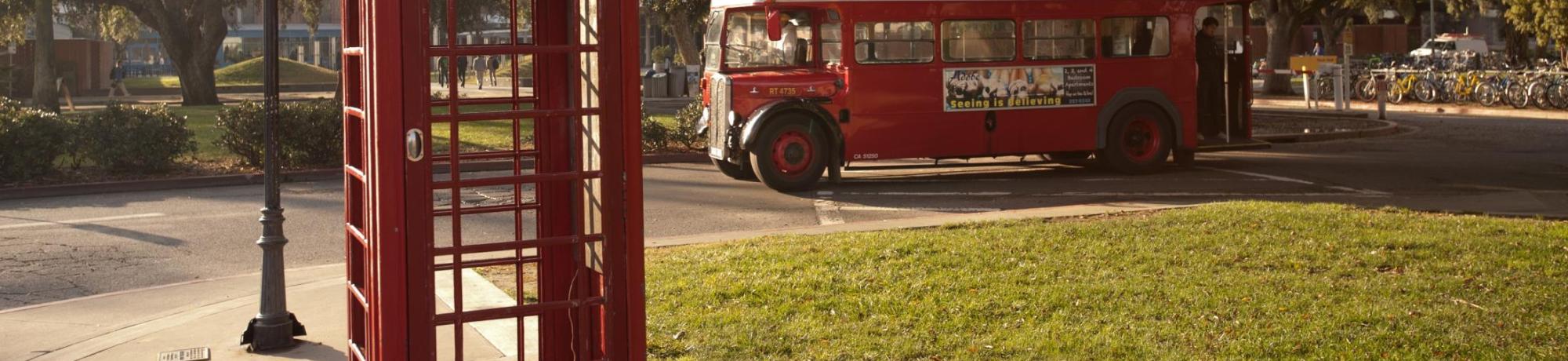 Image: campus grounds with a red vintage phone booth and double-decker bus.